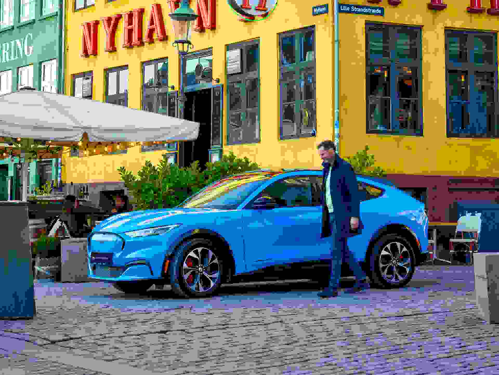 Blue Ford Mustang Mach E Drivers Side Parked At Nyhavn Owner Entering Lightened